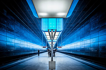 Innenansicht der U-Bahnhofs HafenCity in Hamburg, mit mehreren Wartenden am Bahngleis