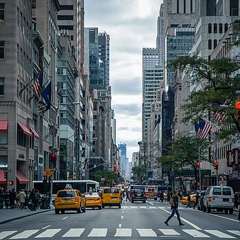 Straßenschlucht in New York mit gelben Taxis und vielen Menschen