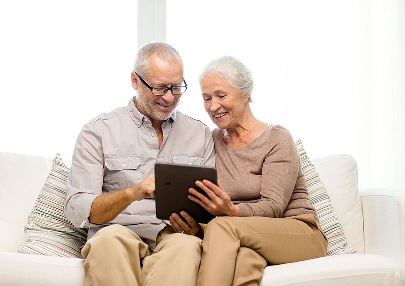 Zwei ältere Menschen schauen auf ein Tablet